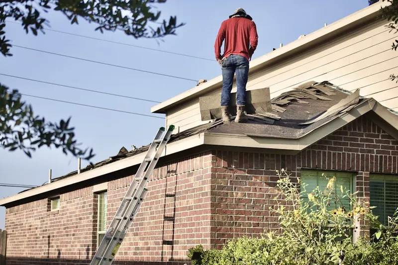 Professional roofer working on a residential roof in Independence